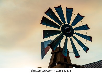 Texas windmill at golden hour sunset glowing in the farm glow