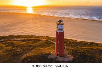 Texel lighthouse during sunset Netherlands Dutch Island Texel in summer with sand dunes at the Wadden Island. drone aerial view from above during sunset at the beach with a sunset in the ocean - Powered by Shutterstock