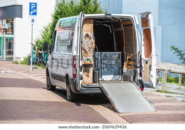 Texel, The Netherlands - Aug 27, 2019: White\
electric Volkswagen transporter van transporting wash dryer and\
washing machines - large home appliance installation transportation\
renovation