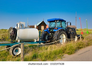 Texel, Netherlands - August 2019: Tractor With Tank Spreader For Applying Pesticides Or Fertilizers On Field Parked On The Side Of The Road