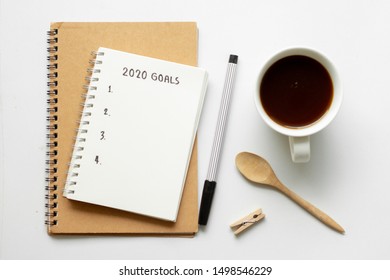 Text 2020 Goals On Notebook With Pen On White Background,office Desk.