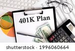 Text 401 K PLAN on Office desk table with keyboard,dollars,calculator ,supplies,analysis chart on the white background.