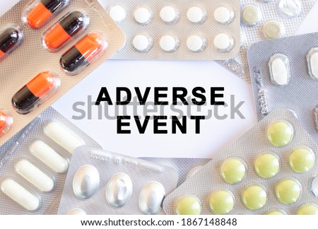 Text ADVERSE EVENT on a white background. There are different medicines around.