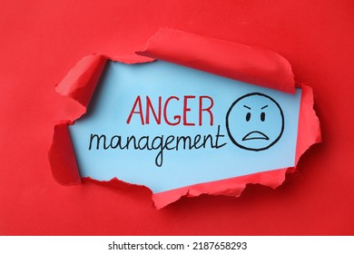 Text Anger Management and drawn angry face on light blue background, view through torn red paper - Shutterstock ID 2187658293