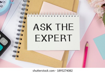 Text ASK THE EXPERT on notepad with office tools, pen on financial report