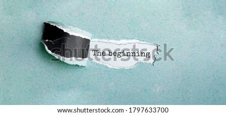 The text The beginning appearing behind torn brown paper