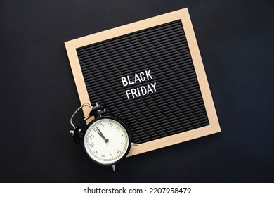 Text Black friday on black letter board and alarm clock on black background. Concept Black friday , season sales time. Flat lay Top view Copy space Template layout for your design