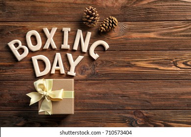 Text BOXING DAY And Gift Box On Wooden Background