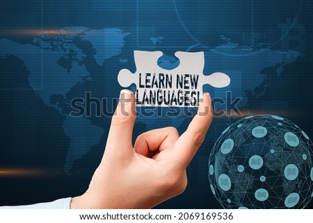Text caption presenting Learn New Languages. Word Written on developing ability to communicate in foreign lang Hand Holding Jigsaw Puzzle Piece Unlocking New Futuristic Technologies.