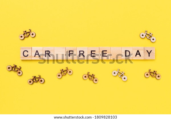Text\
Car Free Day and small bicycles on yellow background. Concept of\
world car free day on September 22. Top view -\
Image