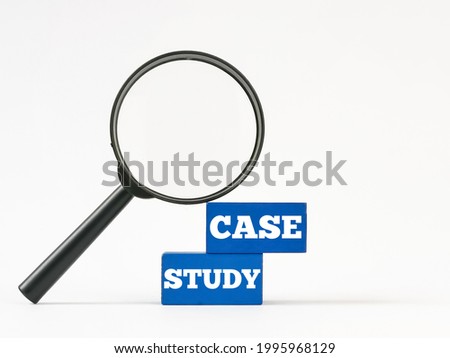 Text case study written on blue wooden blocks with magnifying glass against white background.