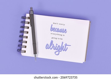 Text 'Don't worry because everything will be alright' in notebook on violet background