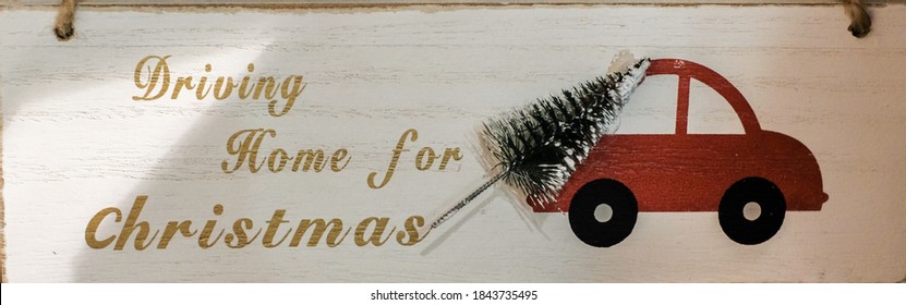 Text Driving Home For Christmas, Sign, Image Of Red Auto With Xmas Tree, Wooden White Background