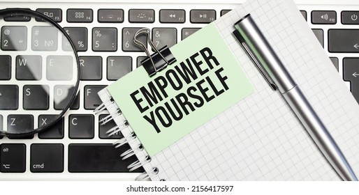 Text Empower yourself on white paper on laptop computer