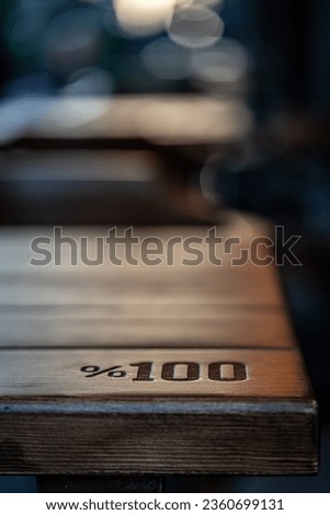 Text Engraved on Wooden Table One Hundred Percent