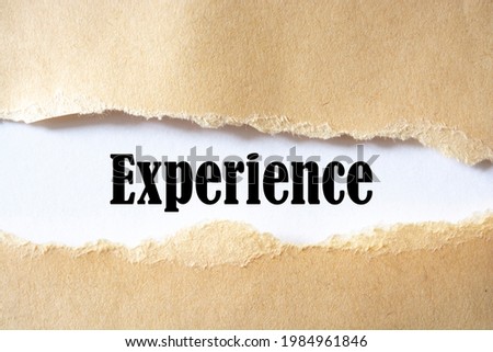 The text, experience, appears behind torn brown paper