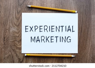 The Text EXPERIMENTAL MARKETING Is Written In A Notebook Which Lies On A Wooden Table. Lettering On A Business Or Financial Theme. Business Concept.