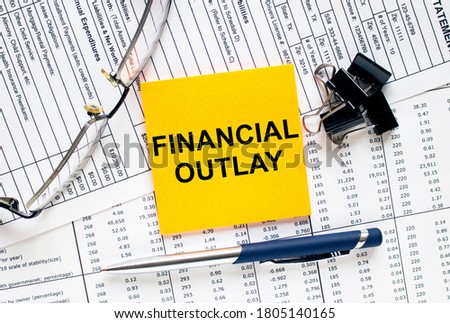 Text Financial Outlay on financial tables with pen, glasses and paper clips. Business and financial conzept