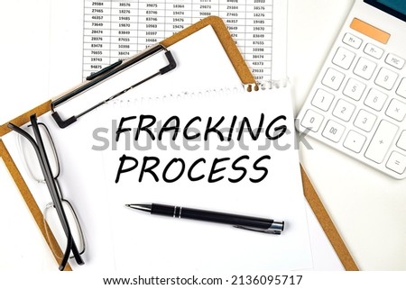 Text FRACKING PROCESS on the white paper on a clipboard with chart and calculator