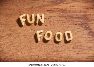 Text Fun Food Formed With Alphabet Soup Pasta Letters On A Wooden Background.