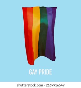 Text Gay Pride And A Rainbow Pride Flag Waving In The Air Against A Blue Background