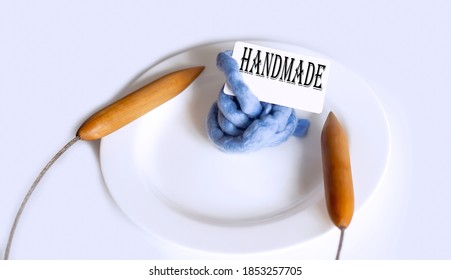 Text HANMADE With Big Knitting Needles On The Plate