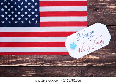 Text Happy 4th of July with american flag on brown wooden table - Shutterstock ID 1413781586