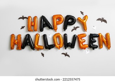 Text HAPPY HALLOWEEN made of balloons and paper bats on light wall - Powered by Shutterstock