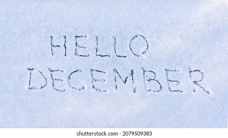 Text HELLO DECEMBER Written On Fresh White Snow With Shining Icy Crystals On Cold Winter Evening. Hello New Month, Welcome Winter Concept. Season Changing