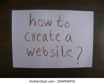 Text how to create a website? written by brown oil pastel on white color paper