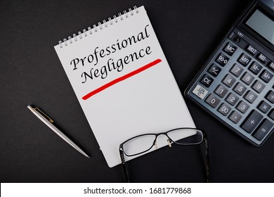 Text, The Inscription, The Phrase Professional Negligence Is Written In A Notebook That Lies On A Dark Table With A Calculator And Pen And Glasses. Business Concept.