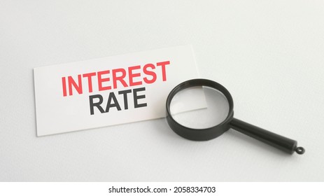 Text Interest Rate On The White Paper Card, On Lens Background, Bisiness Concept