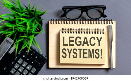 Text LEGACY SYSTEMS on notepad with office tools, pen