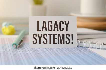 Text LEGACY SYSTEMS on the notepad with office tools, pen
