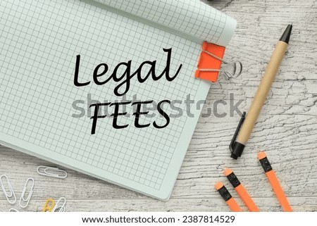 the text LEGAL FEES . Business orange pencils and pen. text on the corner of the notebook