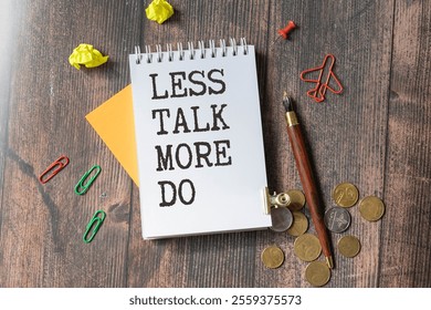 Text LESS TALK MORE DO on brown paper notepad in businessman hands on the table with diagram. Business concept