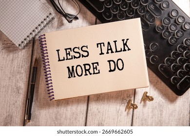 Text LESS TALK MORE DO on brown paper notepad in businessman hands on the table with diagram. Business concept