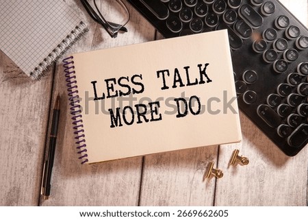 Text LESS TALK MORE DO on brown paper notepad in businessman hands on the table with diagram. Business concept