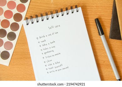 Text List For Self Care On Notebook With Pen On White Background, Office Desk.