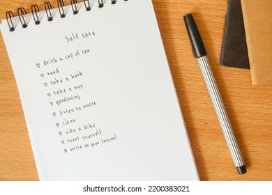 Text List For Self Care On Notebook With Pen On White Background, Office Desk.