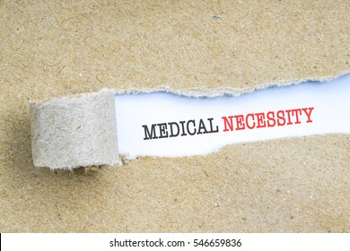 The text MEDICAL NECESSITY behind torn brown paper