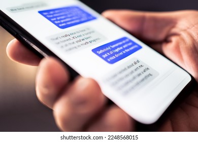 Text message in phone. Send sms with smartphone. Mobile conversation and texting in instant messaging and online chat app in cellphone. Communication in business network. Discussion in dark at night. - Shutterstock ID 2248568015