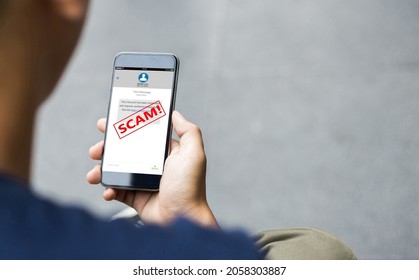 Concept d'escroquerie par SMS ou d'hameçonnage de SMS. Mains d'homme utilisant un smartphone