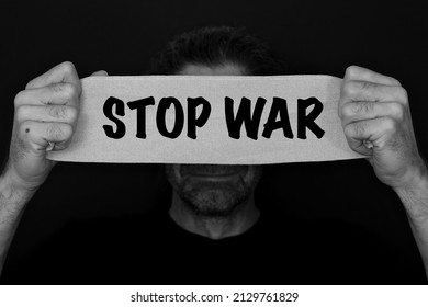 Text message stop war. bearded man with an anxious, fearful expression, with bandage banner in Hand with the text STOP WAR. refugees concept