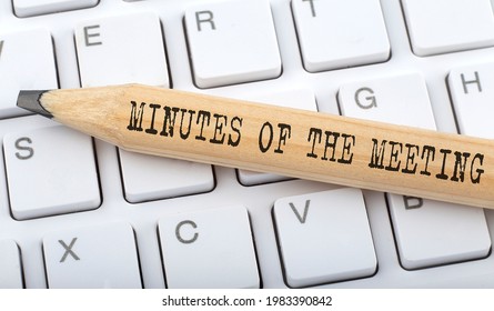 Text MINUTES OF THE MEETING on wooden pencil on white keyboard. Business