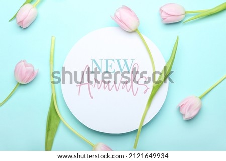 Text NEW ARRIVALS with tulip flowers on blue background