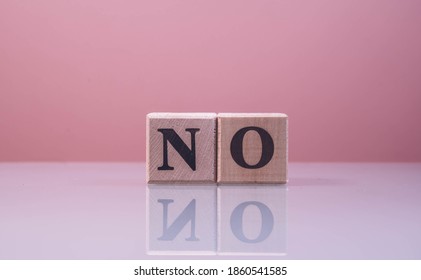 Text NO On Wood Cube Blocks. The Letters NO Written On The Cubes In Black Letters Isolated On A Glass Surface. NO Text For Your Desing.