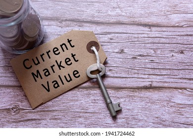 Text On Brown Tag With House Key And Blurred Jar Full Of Coins On Wooden Table - Current Market Value