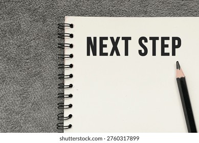 “Next step” text on notebook representing planning, decision making, and future direction.