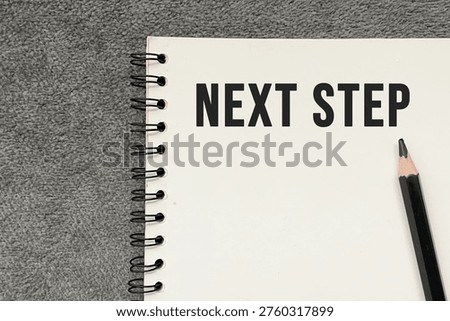 “Next step” text on notebook representing planning, decision making, and future direction.